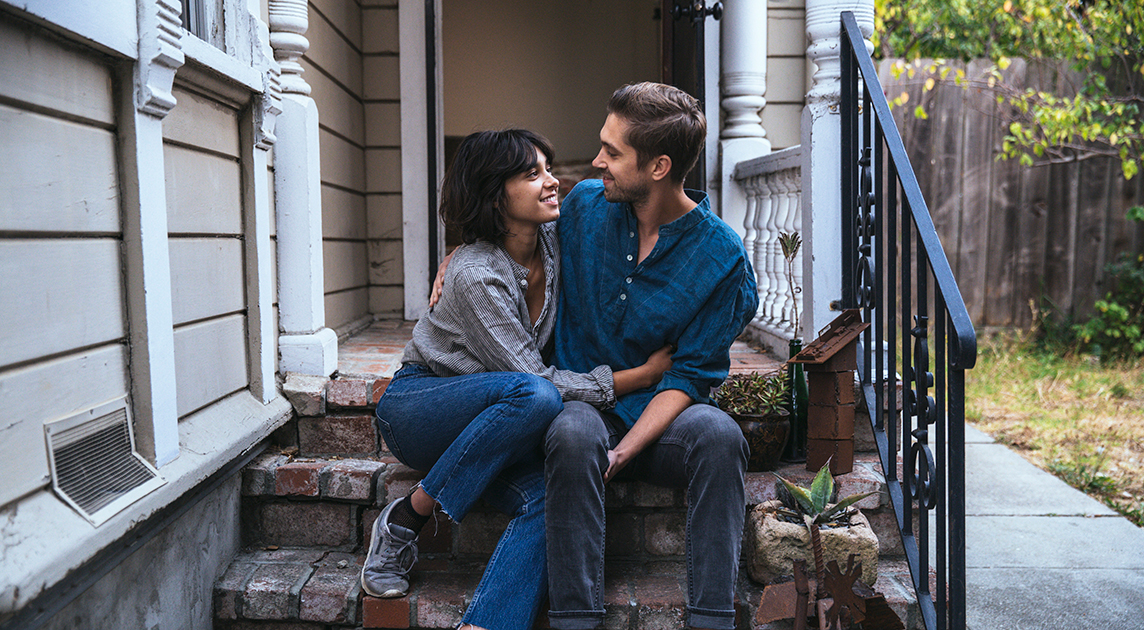 Newlywed Covered California members embrace on their porch.